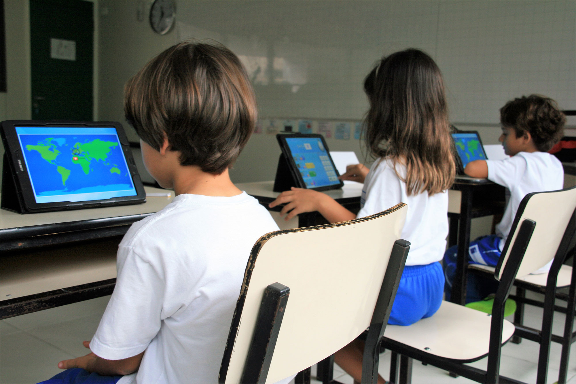 Ein Mädchen und ein Junge lösen konzentriert Matheaufgaben vor einem Computer während des SIS Maths Day.	